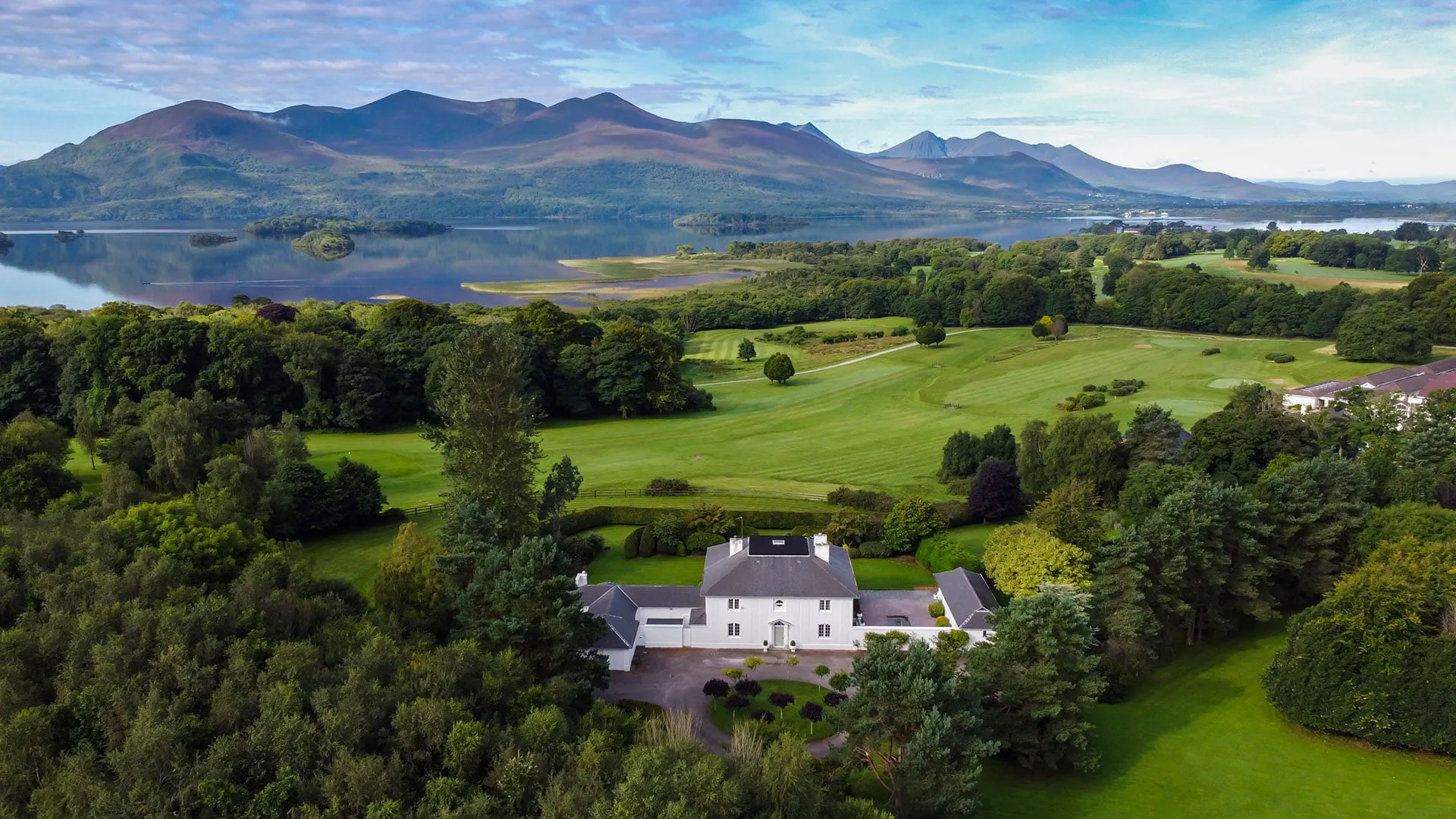 Aerial view of Kenmare House and its grounds, with the Lakes of Killarney and the mountains beyond